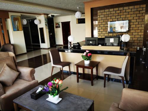 una hall con un bar con sedie e fiori su un tavolo di سمأ الرفاع 1 a Al Khobar