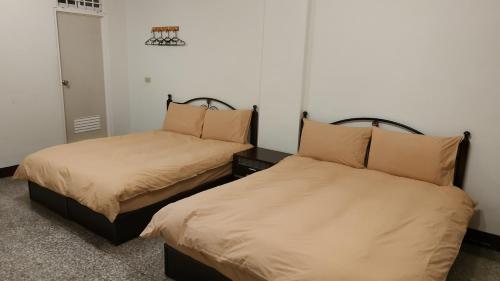 花蓮市にあるLove Hualien Hostelのベッド2台が隣同士に設置された部屋です。