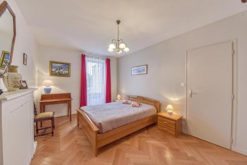 um quarto com uma cama, uma mesa e uma janela em Les Géraniums em Baden