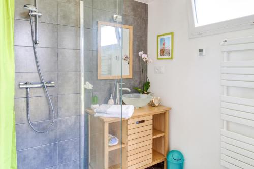 a bathroom with a shower with a sink and a mirror at Le Nominoë in Lampaul-Plouarzel