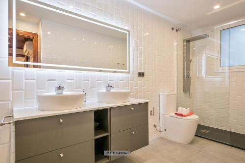 a bathroom with two sinks and a toilet at Alcam Barbera Centro in Barbera del Valles