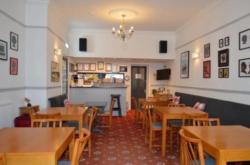 un restaurant avec des tables et des chaises en bois et un comptoir dans l'établissement The Cameo, à Blackpool