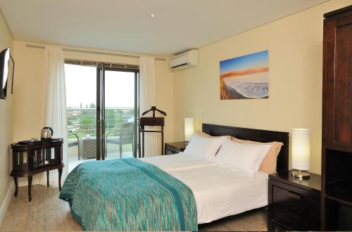 a hotel room with a bed and a balcony at Beach Hotel Swakopmund in Swakopmund