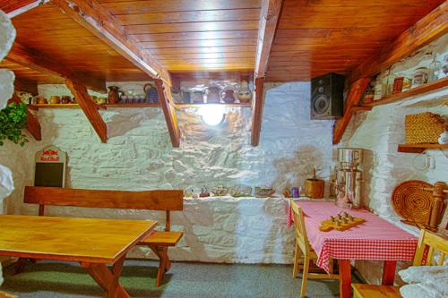 a dining room with a table and a stone wall at Pension Ivanka in Jestrabi V Krkonosich