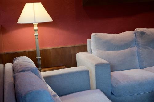 a living room with two chairs and a lamp at Hotel Florido in Sort