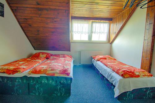 two beds in a room with a attic at Pension Ivanka in Jestrabi V Krkonosich