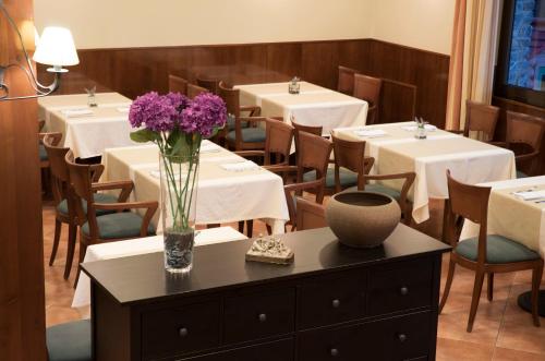 a dining room with tables and a vase of purple flowers at Hotel Florido in Sort