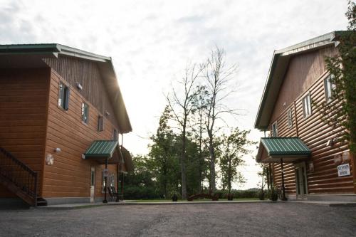 two buildings with green awnings next to each other at Chalets et Spa Lac Saint-Jean in Chambord