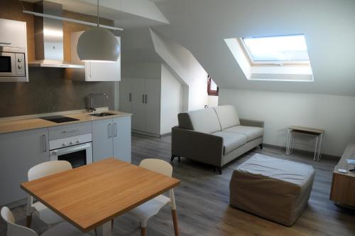 a kitchen and living room with a table and a couch at APARTAMENTOS TURÍSTICOS GUIANA in Ponferrada