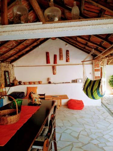 a room with a table and chairs and a hammock at Moita Cottage in Moita