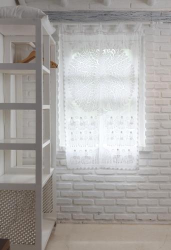a window with a white curtain in a room at Pousada Capim Santo in Trancoso