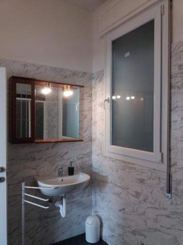 a white bathroom with a sink and a window at Agriturismo Corte Filippi in Villadose
