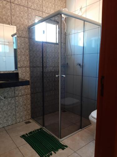 a glass shower in a bathroom with a toilet at Casamatta Hostel - Unidade Aventura in Pirenópolis