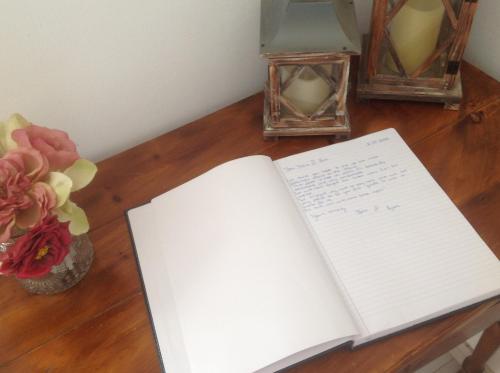 an open book on a table with flowers and candles at The Aegean blue country house Old Milos in Lagoúdi Zía