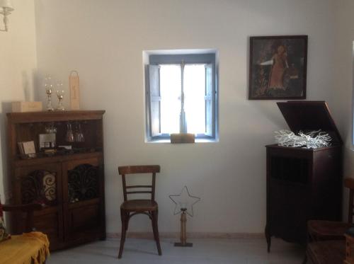 a living room with a chair and a window at The Aegean blue country house Old Milos in Lagoúdi Zía
