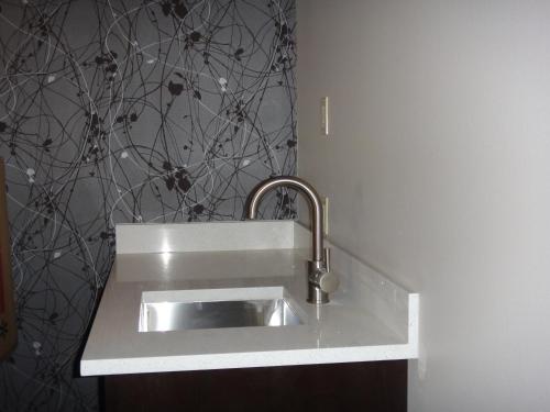 a silver sink in a white counter in a bathroom at Sunrise Inn in Anacortes