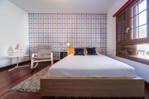 a bedroom with a bed and a chair and a window at Aquavilla in Costa Teguise