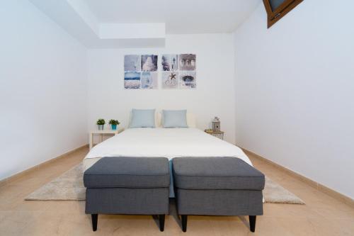 a bedroom with a bed with two ottomans at Aquavilla in Costa Teguise