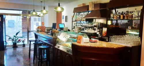 a bar in a restaurant with a counter and stools at Hotel Ristorante Cibarium in Gualdo Tadino