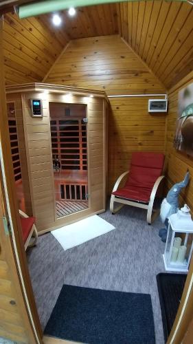 a small room with a sauna with a red bench at Édenkert Apartmanház in Kisvárda
