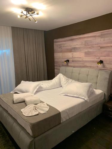 a bedroom with a large bed with a wooden headboard at Doftana Apartaments in Teşila