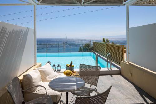a patio with a table and chairs and a pool at Atrium Hotel in Agia Paraskevi
