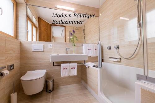 a bathroom with a toilet and a sink and a shower at Hotel Arte in St. Moritz