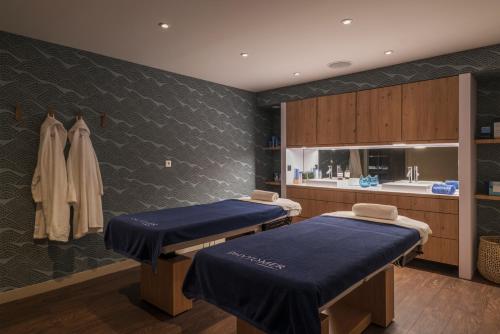 two beds in a hospital room with a sink at Golden Tulip Saint Malo– Le Grand Bé in Saint Malo