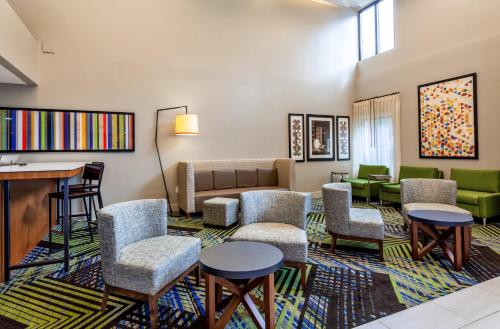 a living room with chairs and a piano at Holiday Inn Express Tampa-Brandon by IHG in Brandon