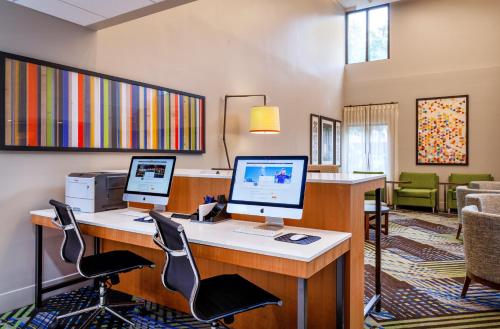 an office with two computers on a desk with chairs at Holiday Inn Express Tampa-Brandon by IHG in Brandon
