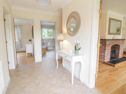 a living room with a fireplace and a table at Hendre in Oswestry