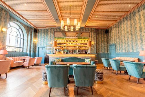 um restaurante com cadeiras azuis e um bar em The Clarence em Dublin