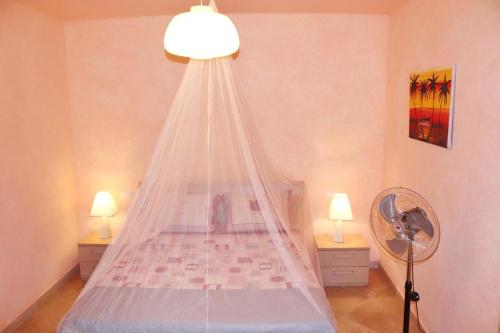 a bedroom with a bed with a mosquito net at Comfortable and spacious apartment with ocean views of Cabral beach in Sal Rei