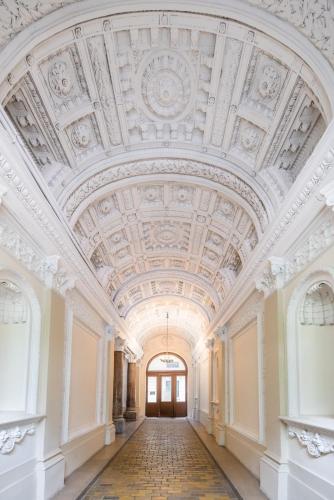 an ornate hallway with a ceiling in a building at Enzo Capo Jacuzzi Andrassy in Budapest