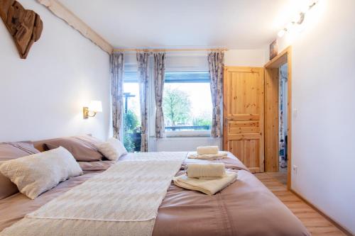 1 dormitorio con 2 camas y ventana en Honey apartments, en Žirovnica