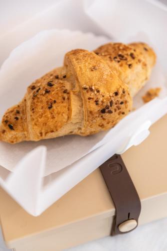 two pieces of bread in a box with a knife at Hotel Suite Inn in Udine