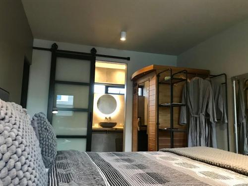 a bedroom with a bed and a sink and a mirror at B&B Tussen Vecht en Veer in Hardenberg