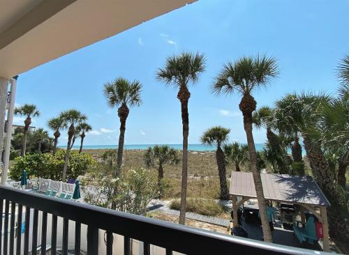 a view of the beach from a balcony with palm trees at All Seasons Vacation Resort by Libertè in St Pete Beach