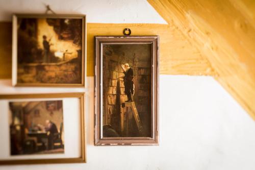 a framed picture of a man on a ladder on a wall at DER SCHWAN Hotel & Restaurant in Schwanstetten