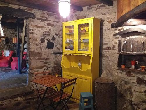a yellow cabinet in a room with a table at Casa dos Livros in Talasnal