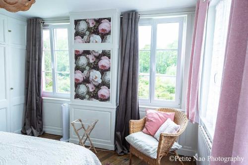 a bedroom with a bed and a chair and windows at Au Jardin des Deux Ponts in Abbeville