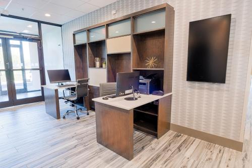 an office with two desks and a computer on a wall at Holiday Inn Knoxville N - Merchant Drive by IHG in Knoxville