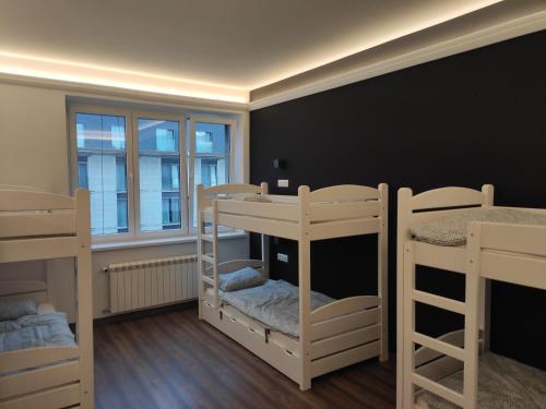 a room with three bunk beds and a window at Greg&Tom Hostel in Krakow