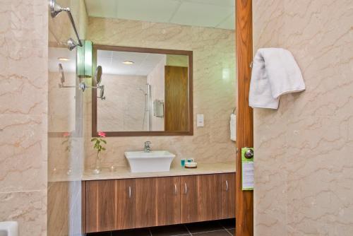 a bathroom with a sink and a mirror at Natura Beach Hotel And Villas in Polis Chrysochous