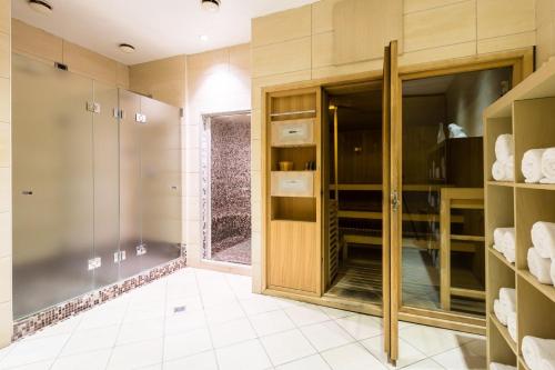 a bathroom with a walk in closet with glass doors at Crowne Plaza Milan - Malpensa Airport by IHG in Case Nuove