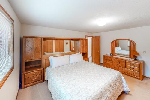 Schlafzimmer mit einem Bett, einer Kommode und einem Spiegel in der Unterkunft Captain Bill's Beachhouse in Lincoln City