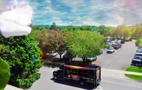a bus driving down a street with parked cars at Centerstone Plaza Hotel Soldiers Field - Mayo Clinic Area in Rochester