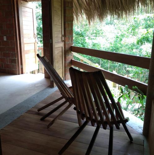 a wooden bench sitting on a porch with a window at Posada Nuuna Mazunte in Mazunte