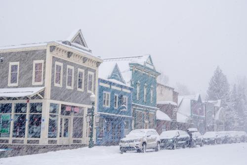 a city street with cars covered in snow at Updated 1 Bedroom Condo in Mountaineer Square condo in Crested Butte
