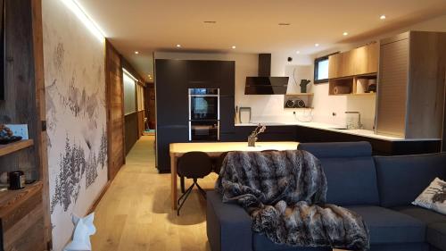 sala de estar con sofá azul y cocina en spot, exceptl 80 m2, centre Alpe d Huez, ski au pied, Ménandière, 8 pers, 3ch, 3sdb, en L'Alpe-d'Huez